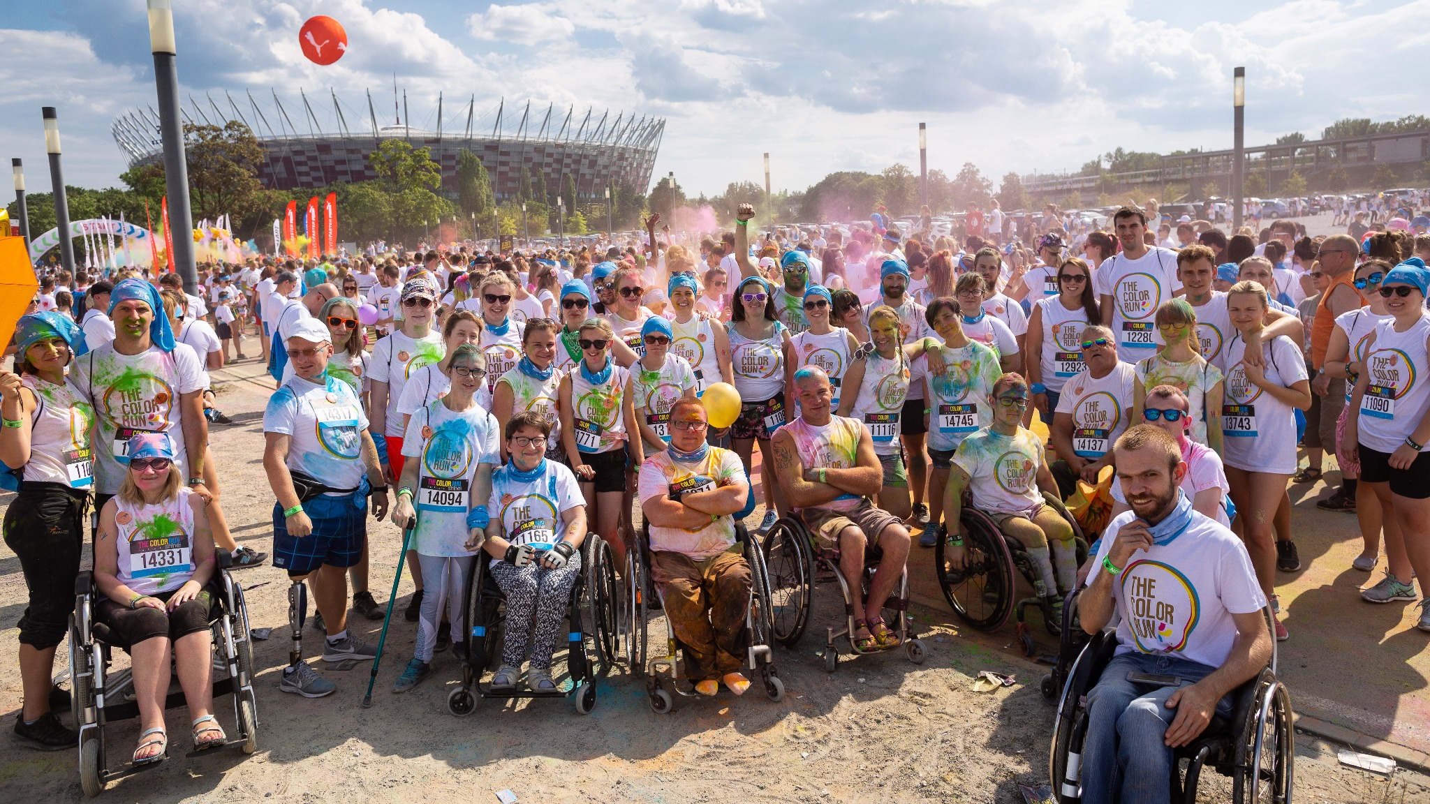 Uczestnicy biegu The Color Run na tle Stadionu Narodowego.